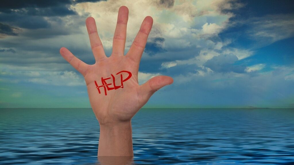 une main qui sort de l'eau, sur la main est inscrit en rouge "help"